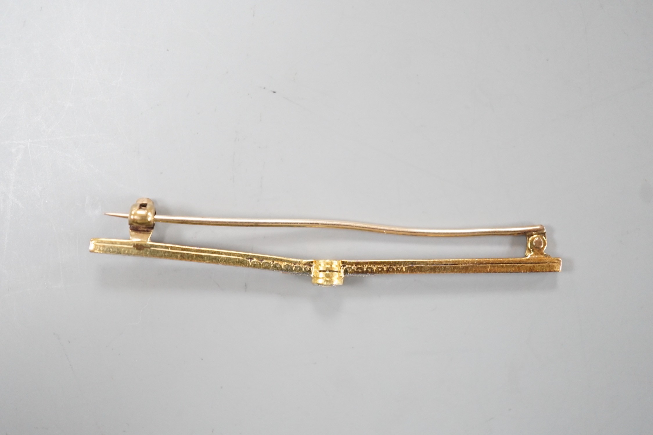 An Edwardian 15ct and single stone diamond set bar brooch, with diamond chip setting, 57mm, gross weight 3.1 grams.
